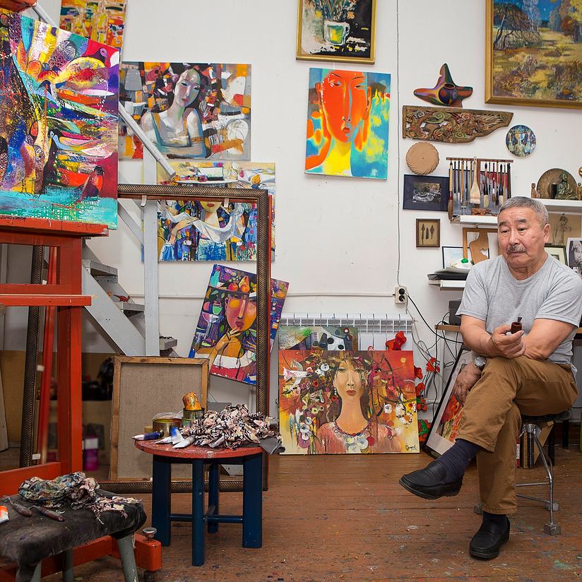 artist posing with his paintings