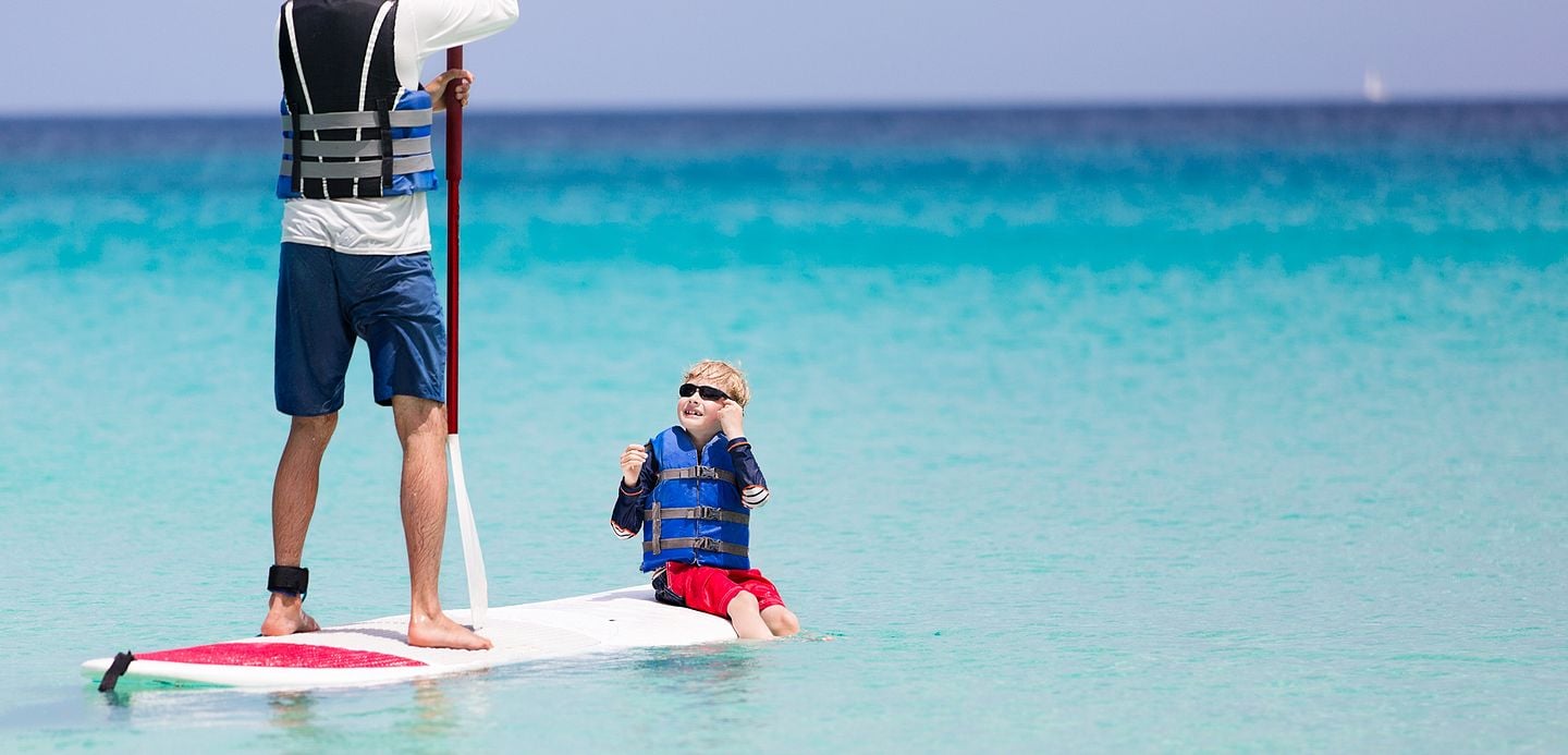 dad and son on a paddle board